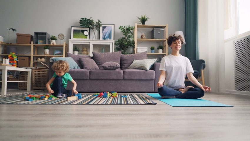 a woman and a child sitting on a rug in a living room